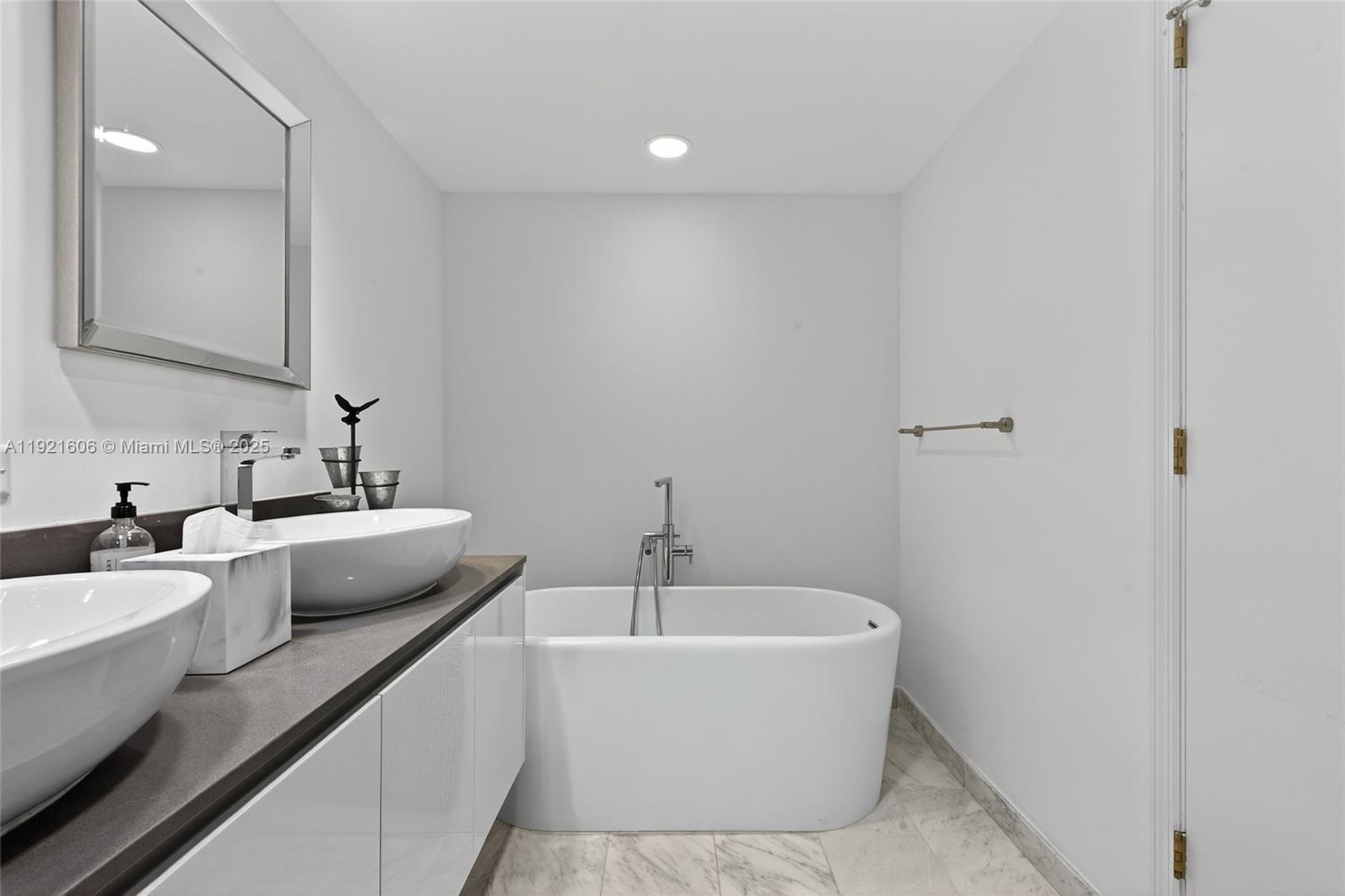 9821 East Bay Harbor Drive, Unit 402 Bay Harbor Islands, FL 33154 - Photo 17 of 34 a bathroom with a bathtub a sink and mirror