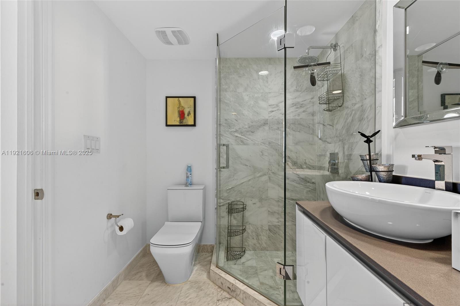 9821 East Bay Harbor Drive, Unit 402 Bay Harbor Islands, FL 33154 - Photo 18 of 34 a bathroom with a granite countertop sink a toilet a mirror and shower