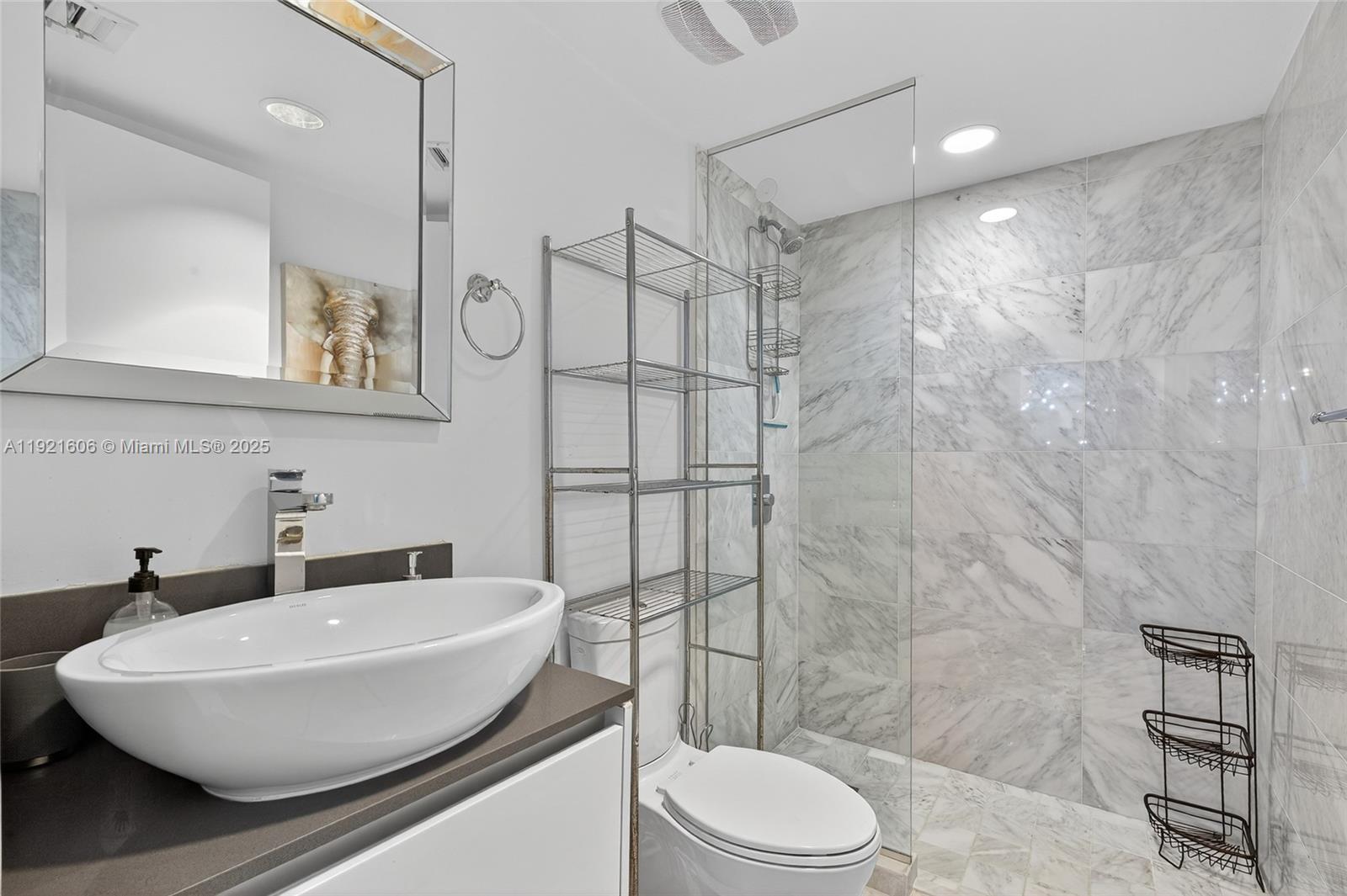 9821 East Bay Harbor Drive, Unit 402 Bay Harbor Islands, FL 33154 - Photo 25 of 34 a bathroom with a sink a toilet and shower