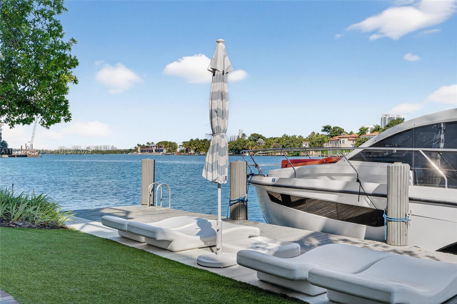 9821 East Bay Harbor Drive, Unit 402 Bay Harbor Islands, FL 33154 - Photo 29 of 34 a view of a terrace with a table and chairs under an umbrella