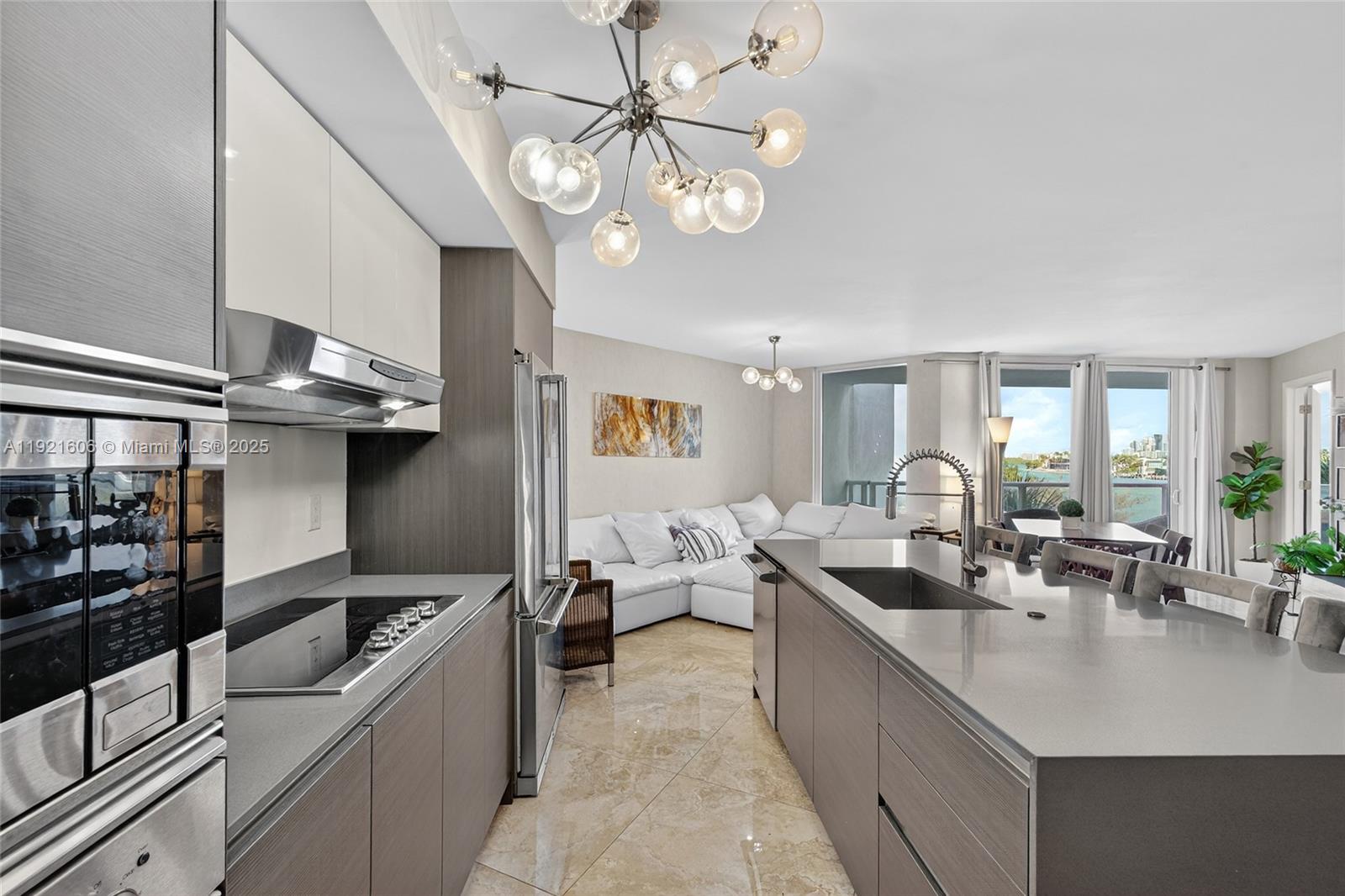 9821 East Bay Harbor Drive, Unit 402 Bay Harbor Islands, FL 33154 - Photo 6 of 34 a kitchen with stainless steel appliances granite countertop a sink counter space and living room view