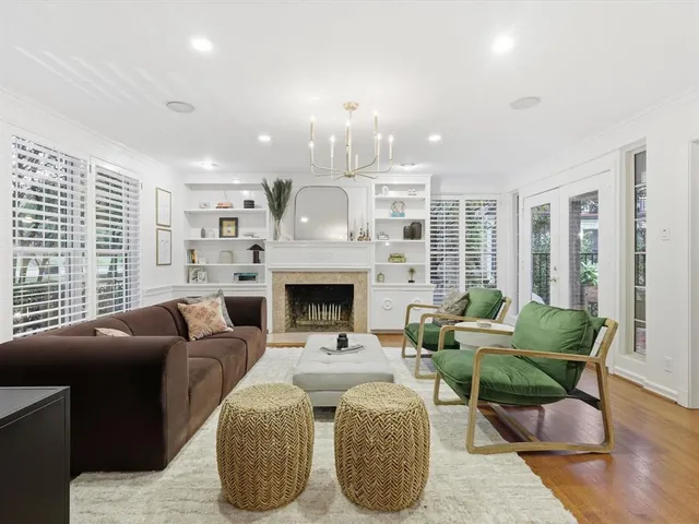 a living room with furniture a fireplace and a large window