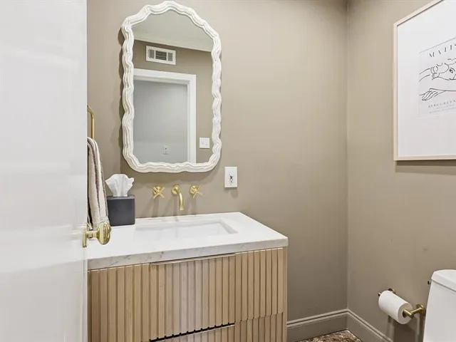 a bathroom with a toilet sink and mirror