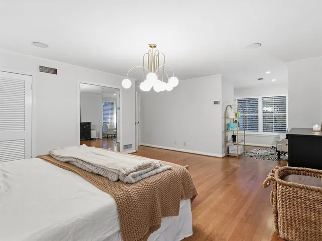 a bedroom with bed and wooden floor