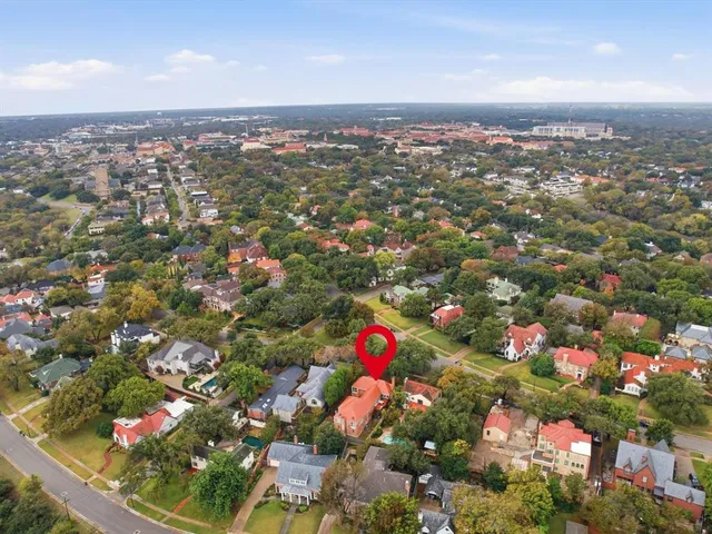 an aerial view of residential houses with outdoor space and trees