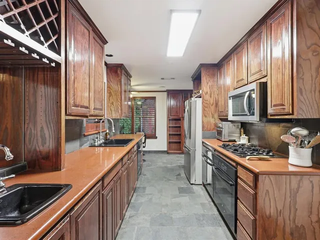 a kitchen with stainless steel appliances a sink stove and cabinets