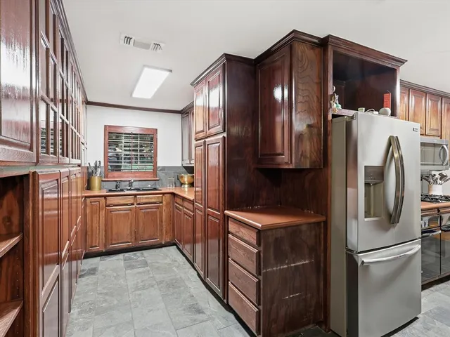 a kitchen with stainless steel appliances granite countertop a refrigerator and a sink