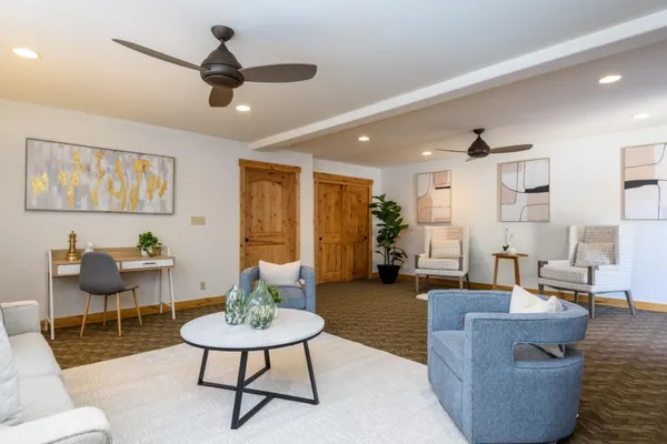 a living room with furniture a rug and a chandelier