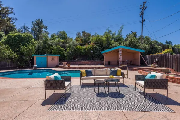 a view of backyard with seating space and wooden fence