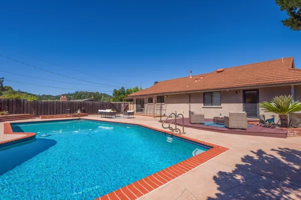 a view of an house with swimming pool and sitting area