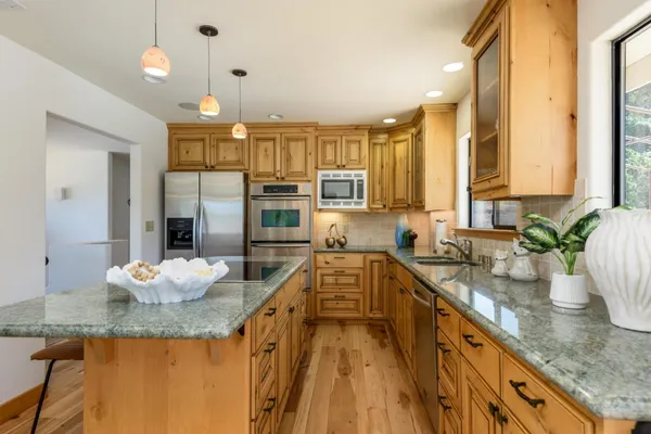 a kitchen with stainless steel appliances granite countertop sink stove and cabinets