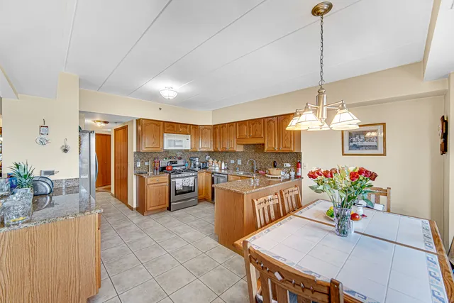 a view of a dining room and livingroom with furniture wooden floor a chandelier