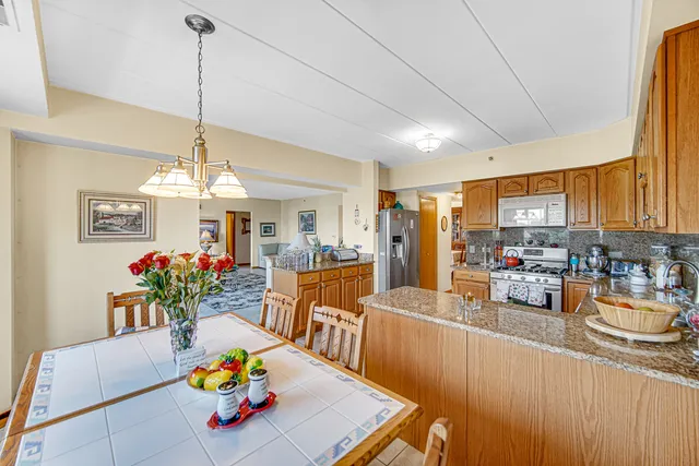 a view of a dining room and livingroom with furniture wooden floor a chandelier