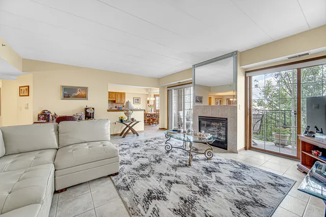 a living room with furniture a fireplace and a floor to ceiling window