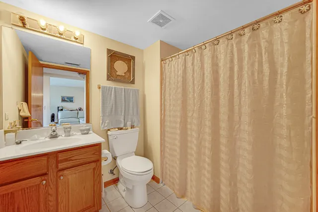 a bathroom with a sink a toilet and shower curtain