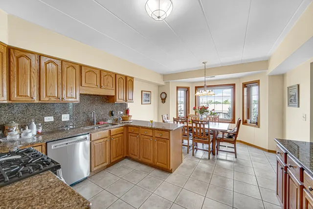 a kitchen with lots of white cabinets appliances and furniture
