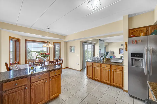a large kitchen with kitchen island granite countertop a large counter top cabinetry and stainless steel appliances