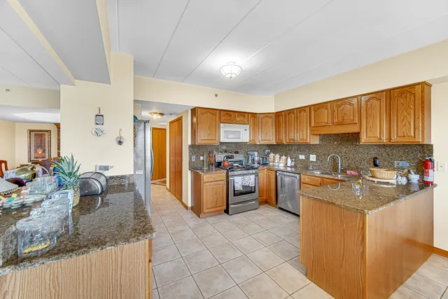 a kitchen with granite countertop a sink counter top space appliances and cabinets