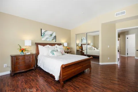 a spacious bedroom with a bed and a wooden floor