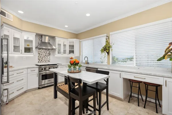 a kitchen with a stove a table and chairs in it