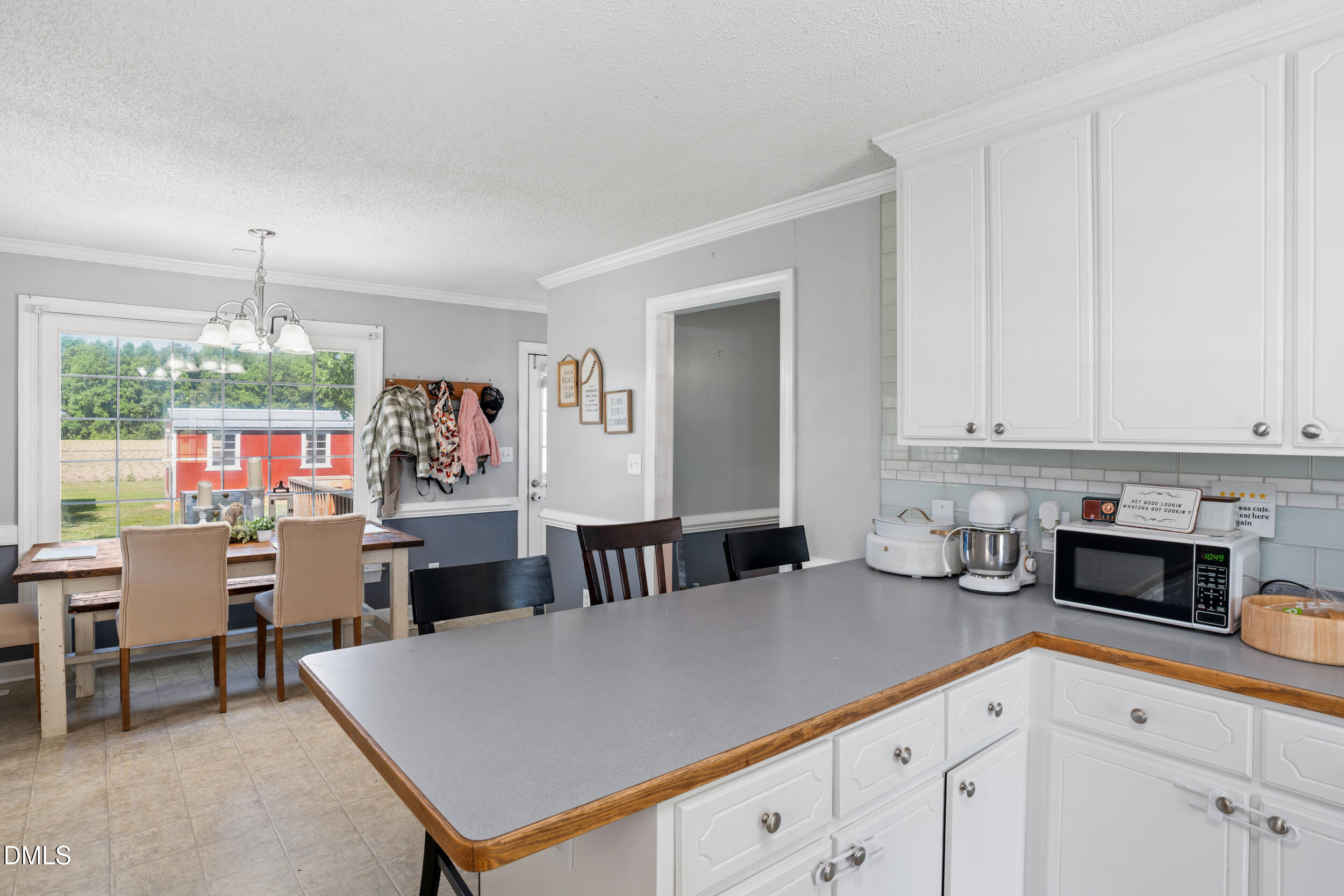 311 Bridgers Road Kenly, NC 27542 - Photo 11 of 46 a kitchen with stainless steel appliances kitchen island granite countertop a table chairs in it and white cabinets