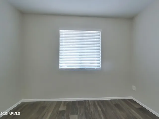 a view of a small space with wooden floor and a window