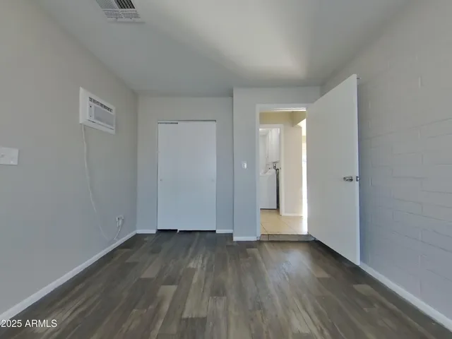 a view of a small space with wooden floor and a window