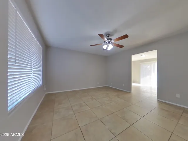 a view of an empty room with a chandelier fan