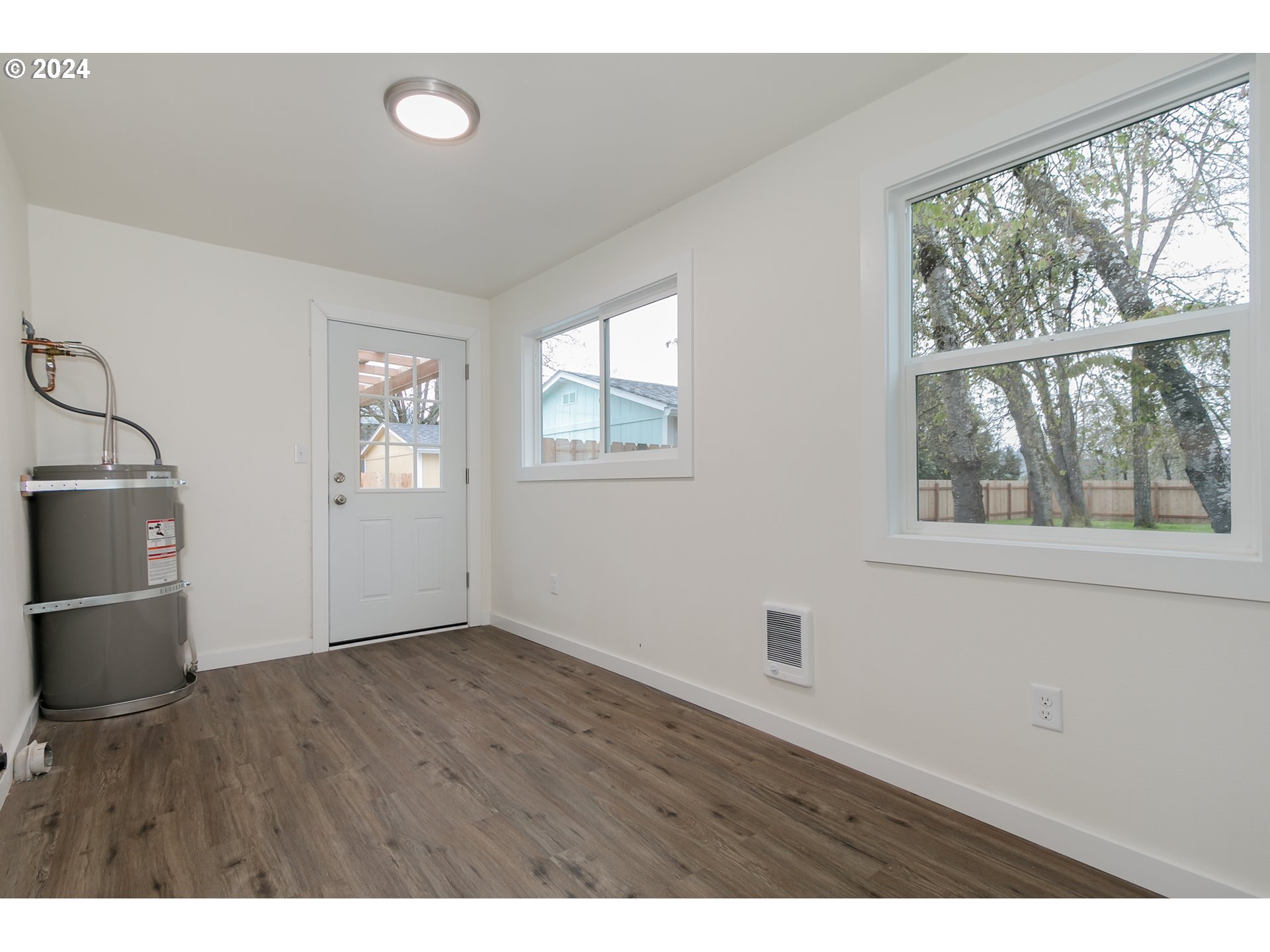 144 South 15th Street Springfield, OR 97477 - Photo 18 of 35 an empty room with wooden floor and windows