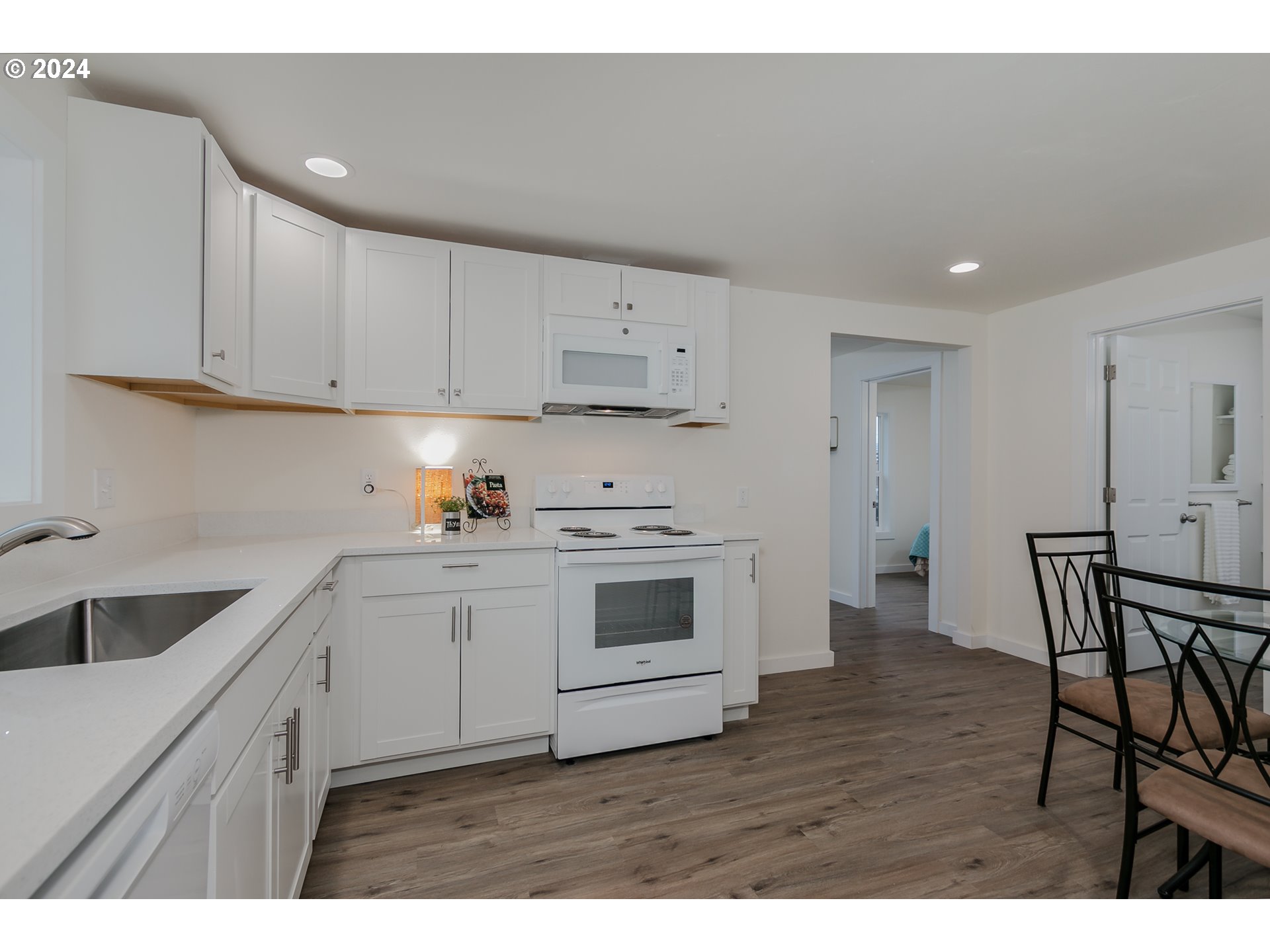 144 South 15th Street Springfield, OR 97477 - Photo 5 of 35 a kitchen with a white cabinets and wooden floor