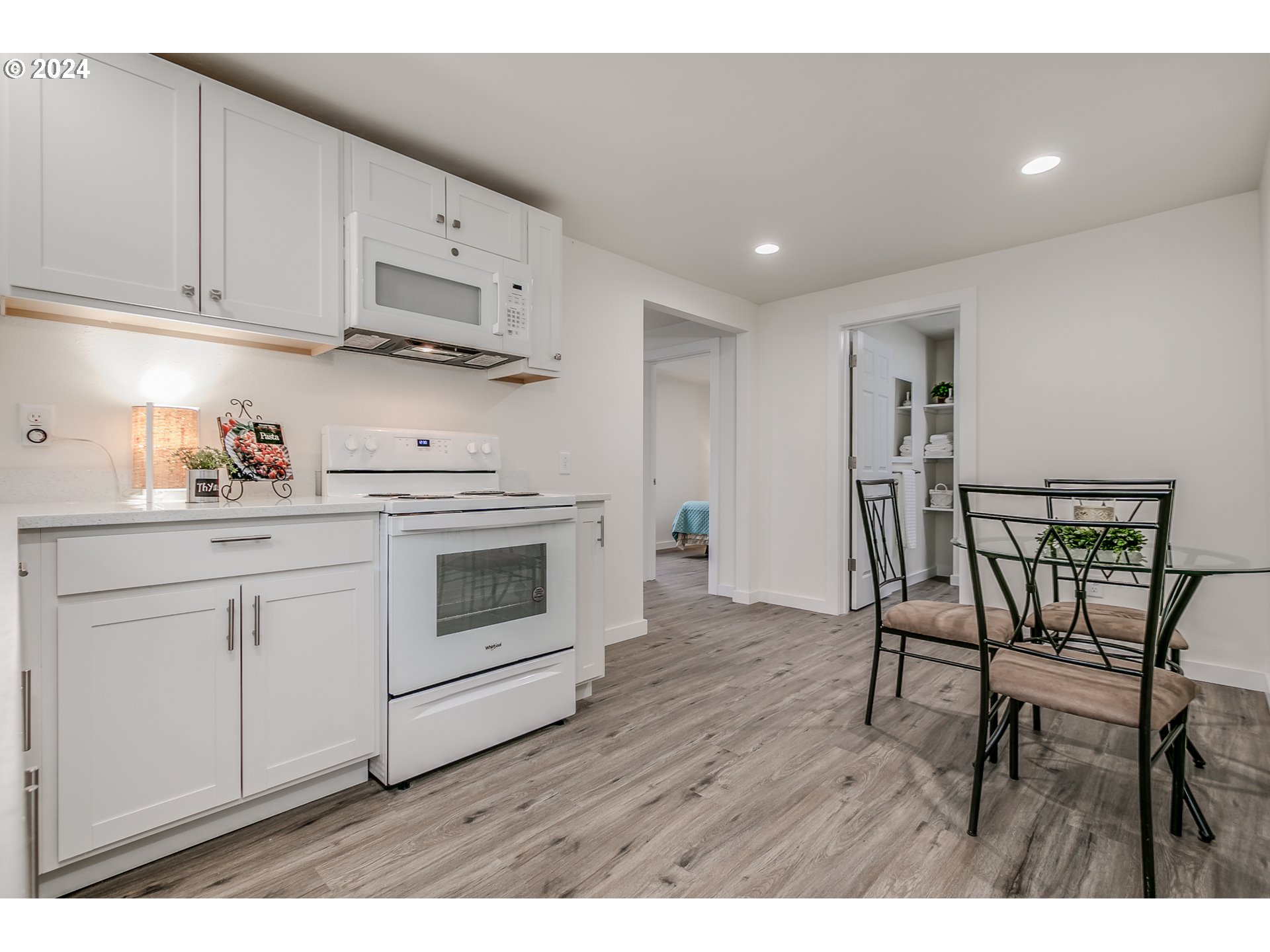 144 South 15th Street Springfield, OR 97477 - Photo 6 of 35 a kitchen with stainless steel appliances white cabinets and wooden floor