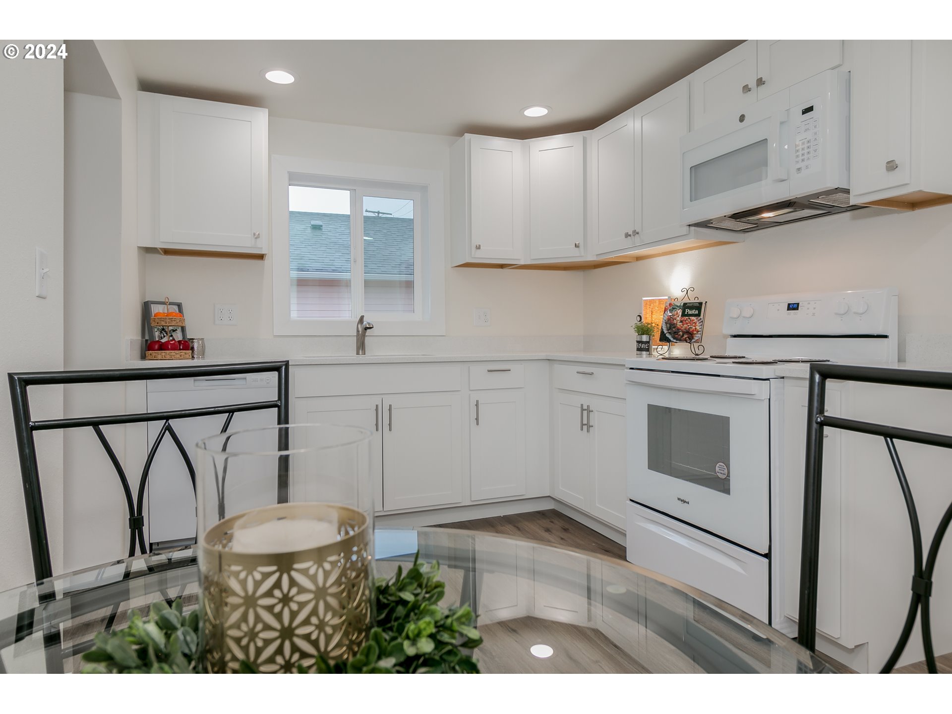 144 South 15th Street Springfield, OR 97477 - Photo 8 of 35 a kitchen with stainless steel appliances a stove a sink and white cabinets