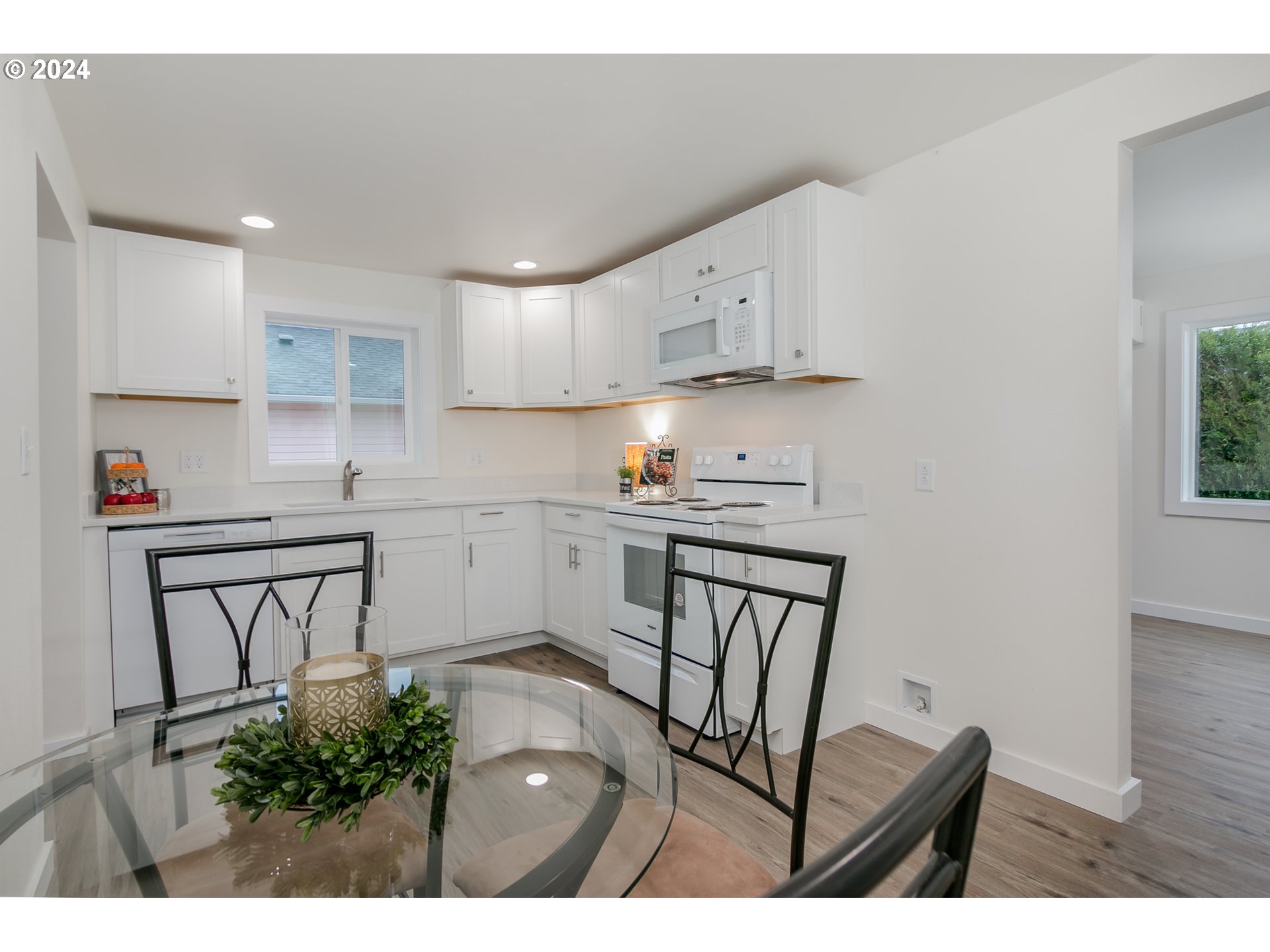 144 South 15th Street Springfield, OR 97477 - Photo 9 of 35 a kitchen with stainless steel appliances granite countertop a stove a sink a refrigerator and white cabinets with wooden floor