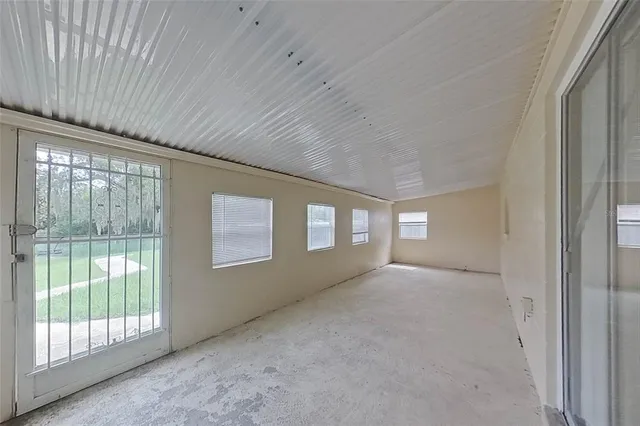 a view of an empty room with glass door and balcony