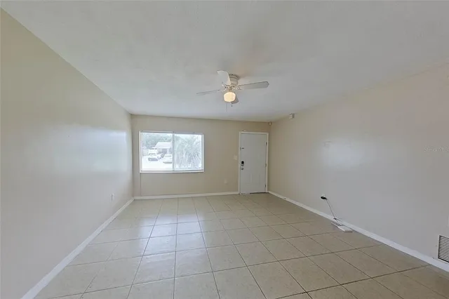 an empty room with windows and fan