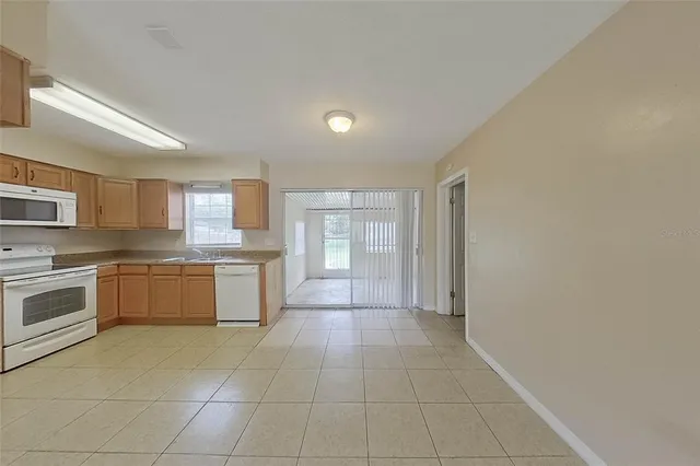 a large kitchen with a stove top oven and white cabinets