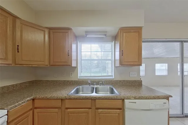 a kitchen with a granite countertop sink and cabinets