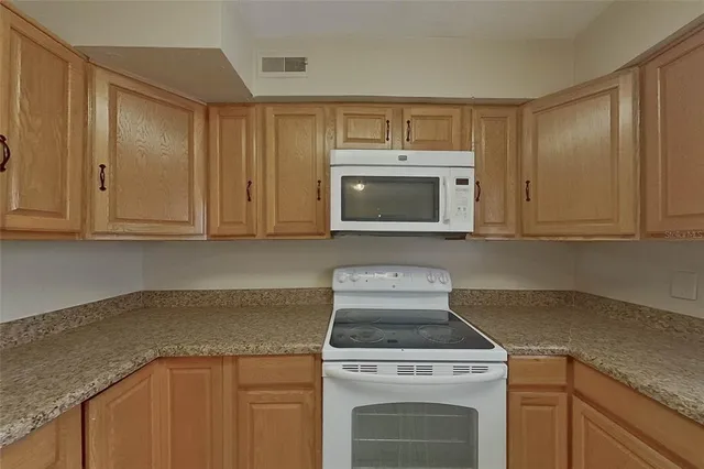 a stove top oven sitting inside of a kitchen