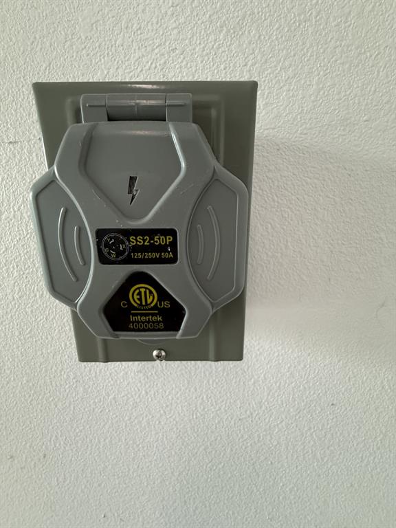 505 Thomas Street Terrell, TX 75160 - Photo 36 of 38 Gray electrical outlet with a hinged cover, rated 125/250V and 50A, mounted on a textured white wall