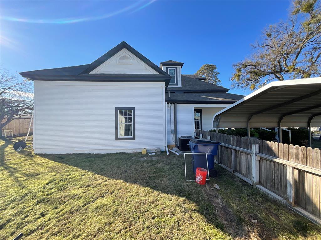 207 College Street Chico, TX 76431 - Photo 5 of 20 Rear view of property featuring a shingled roof and a carport