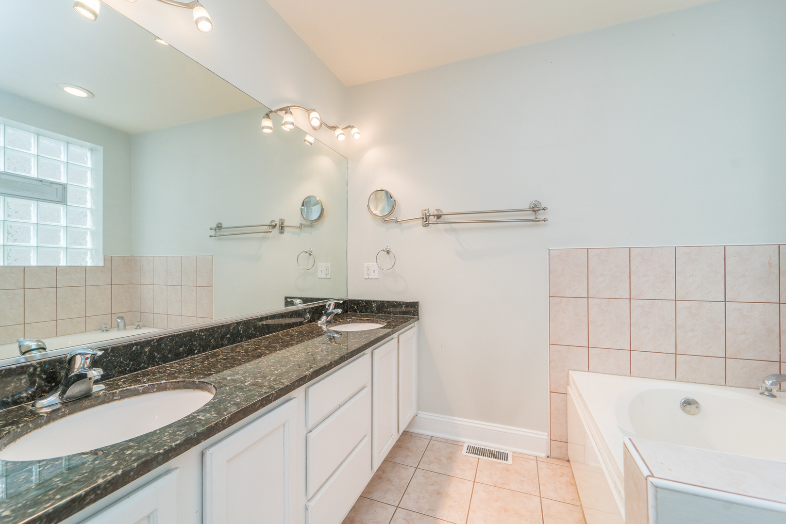 7509 West Irving Park Road, Unit 1 Chicago, IL 60634 - Photo 11 of 28 a bathroom with a granite countertop bathtub sink vanity and mirror