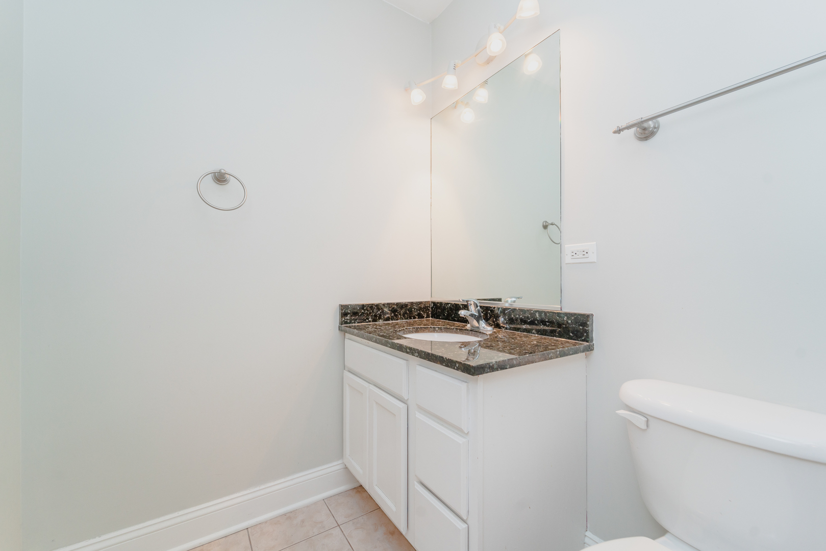 7509 West Irving Park Road, Unit 1 Chicago, IL 60634 - Photo 14 of 28 a bathroom with a granite countertop sink and a toilet