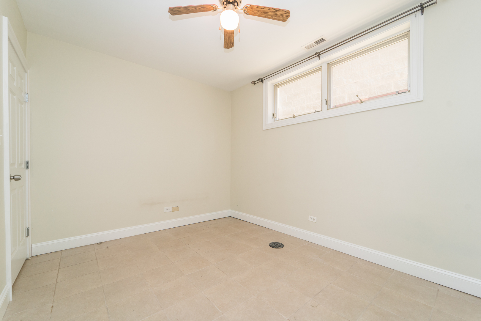 7509 West Irving Park Road, Unit 1 Chicago, IL 60634 - Photo 20 of 28 an empty room with a window and a ceiling fan