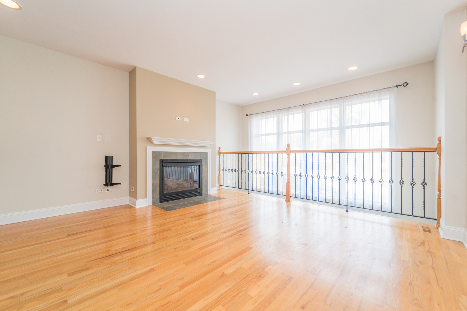 7509 West Irving Park Road, Unit 1 Chicago, IL 60634 - Photo 3 of 28 a view of a livingroom with wooden floor and fireplace