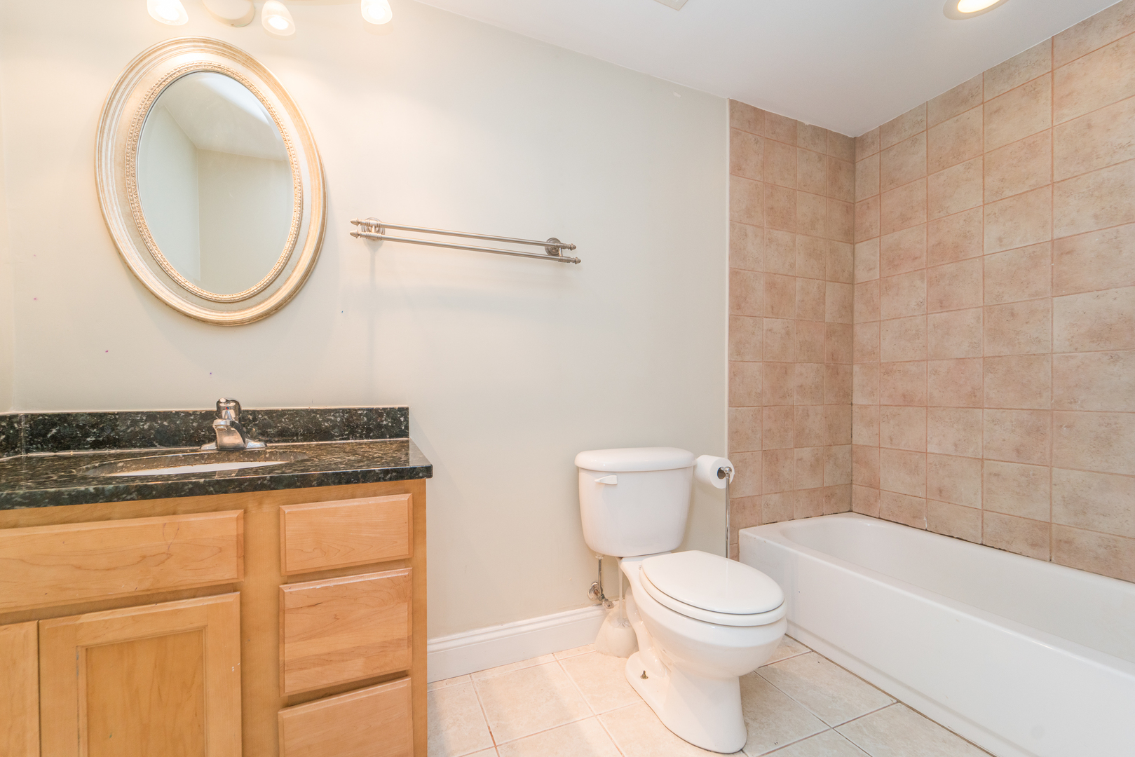 7509 West Irving Park Road, Unit 1 Chicago, IL 60634 - Photo 21 of 28 a bathroom with a granite countertop toilet a sink and a mirror