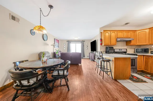 a kitchen with stainless steel appliances granite countertop a refrigerator and a stove top oven