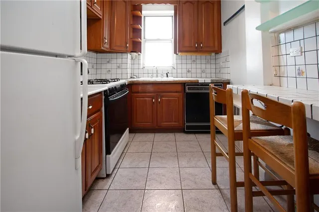 a kitchen with a sink a stove cabinets and a window