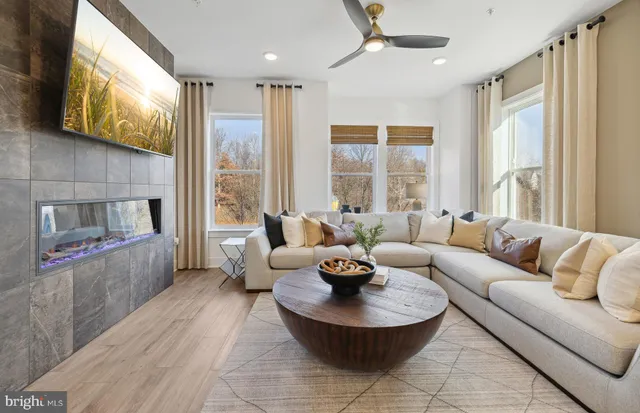 a living room with fireplace furniture and a large window