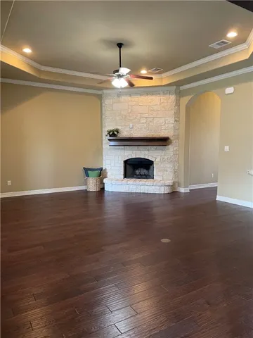 a view of empty room with wooden floor and fireplace