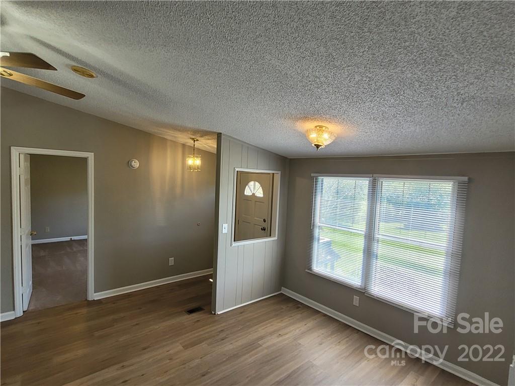 309 Johnson Dairy Road Mooresville, NC 28115 - Photo 8 of 19 an empty room with wooden floor and windows